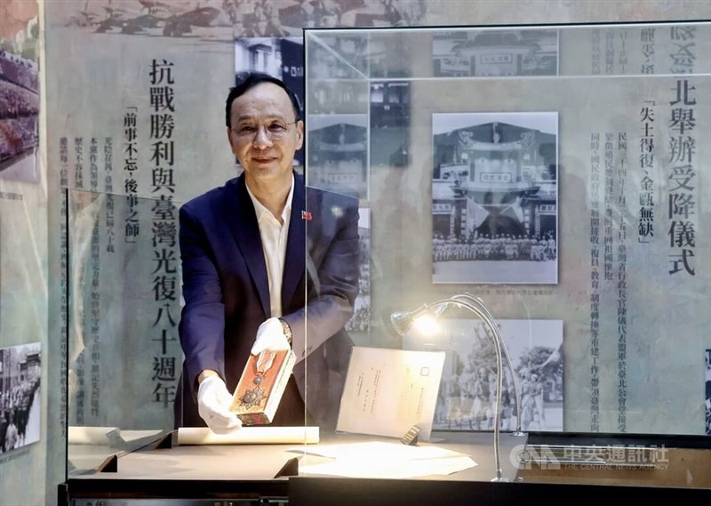 「抗戦勝利勲章」を展示ケースに入れる国民党の朱立倫主席＝8月13日、台北市