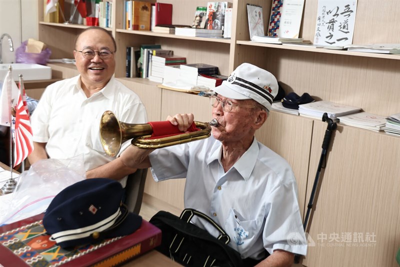 日本海軍の起床ラッパを吹く台湾人元日本兵の周良仁さん（右）