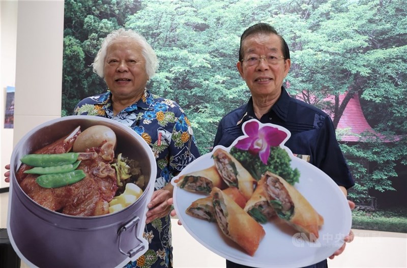 「劉の店」の看板料理を示す宣伝物を手にして微笑む劉俊茂さん（左)と謝長廷総統府資政（顧問）＝2025年8月15日、中央社記者趙世勳撮影