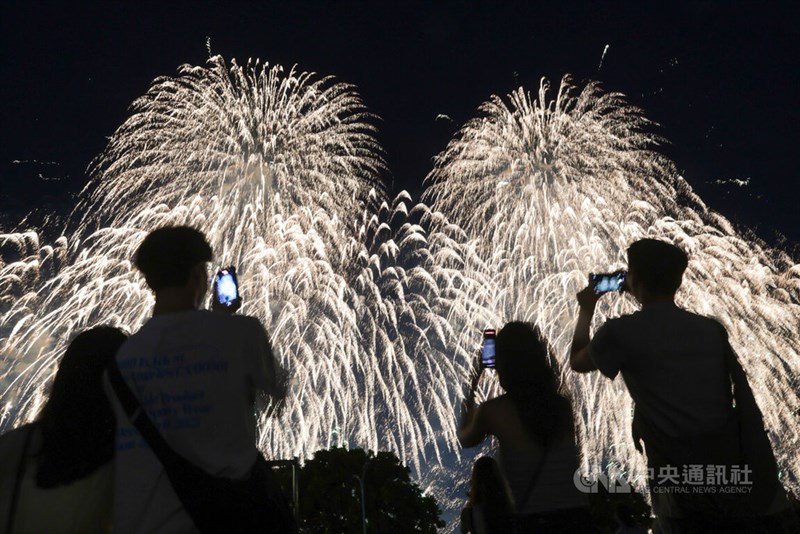 スマートフォンで撮影しながら花火を鑑賞する人々＝中央社記者裴禛撮影