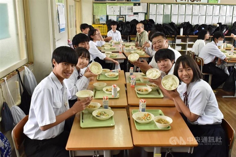 台湾米を手に笑顔を見せる生徒ら