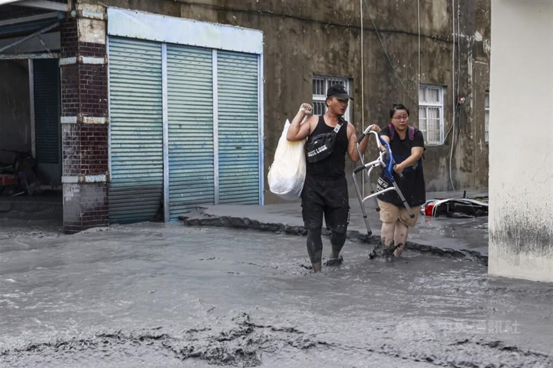 水やぬかるみで車両が進入できないため、徒歩で必需品を取りに一時帰宅した住民＝2025年9月24日、中央社記者鄭清元撮影