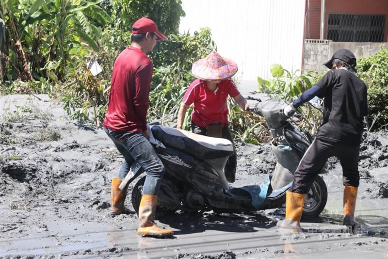 力を合わせてスクーターを移動させる人たち＝2025年9月25日、中央社記者郭日暁撮影