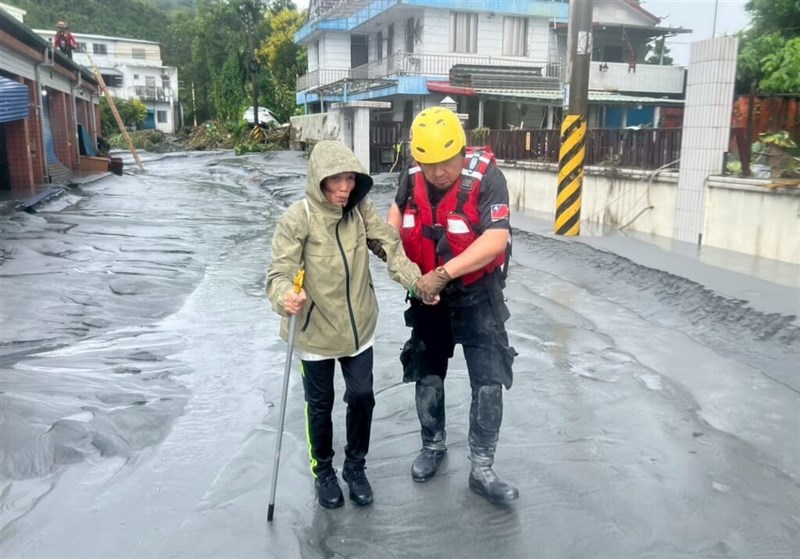高齢者の避難に付き添う救助作業員＝新北市政府消防局提供