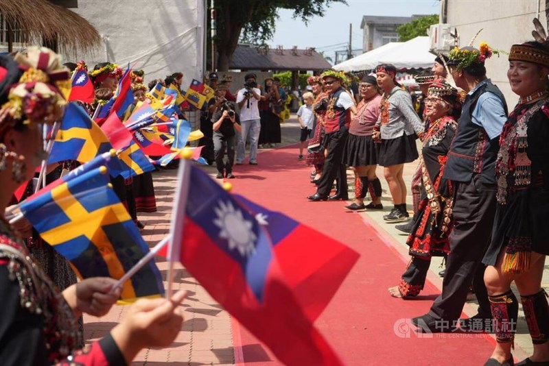 特別展の開幕式で手を取り合って踊りを披露するパイワン族の人たちとスウェーデン側の関係者＝10月1日、屏東県
