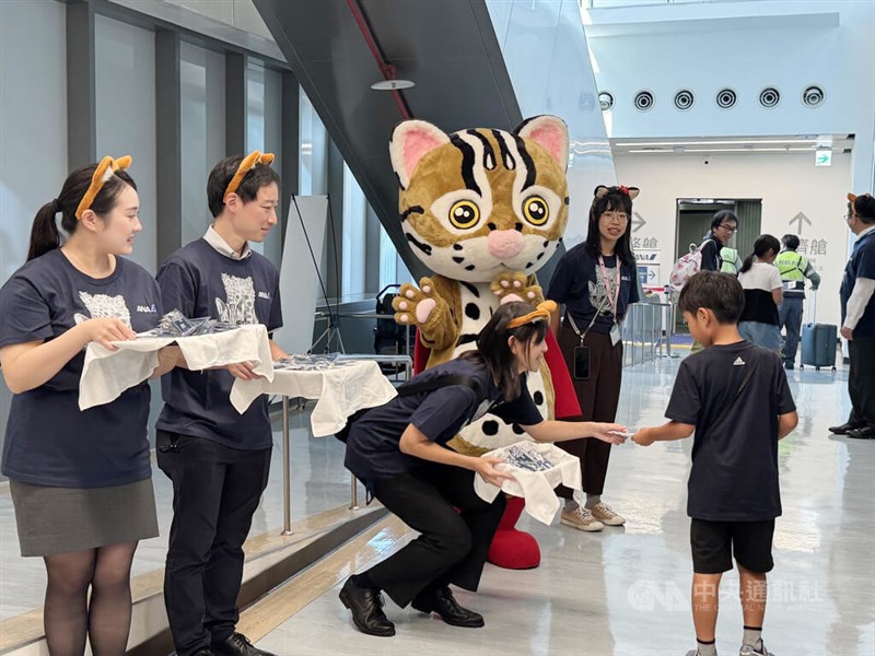 羽田行きの便に搭乗する客に特製のグッズを配布する全日空の職員ら＝2025年10月5日、台北松山空港で中央社記者余暁涵撮影