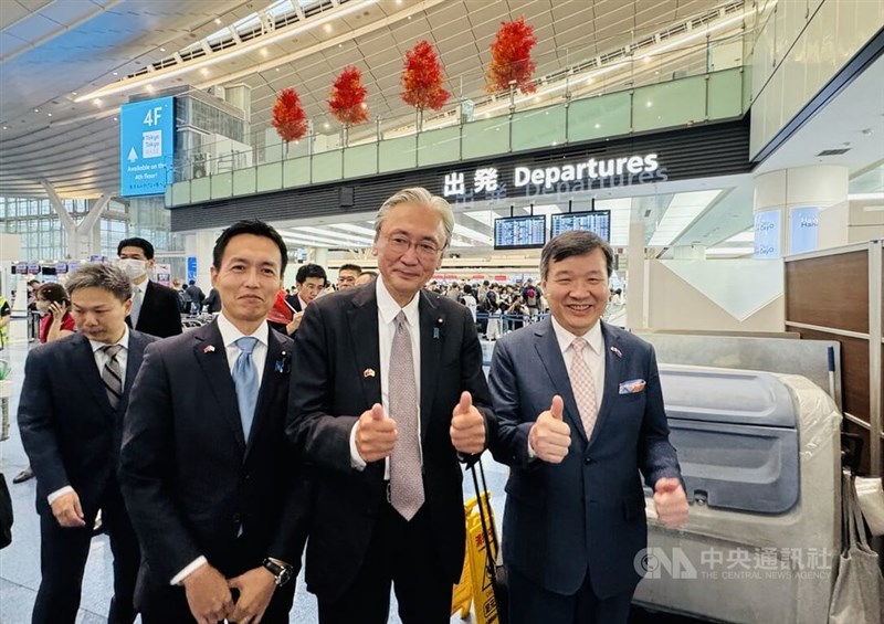 ポーズを決める(右から)李逸洋駐日代表、日華懇会長の古屋圭司衆院議員。手前左は平沼正二郎衆院議員=10月9日、羽田空港