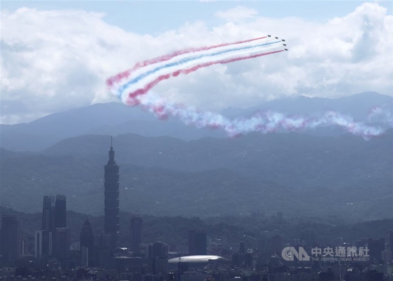 赤青白のスモークを出しながら台北市上空を飛行する空軍のアクロバット飛行チーム「サンダータイガース」の高等練習機「勇鷹」＝2025年10月10日、中央社記者趙世勲撮影