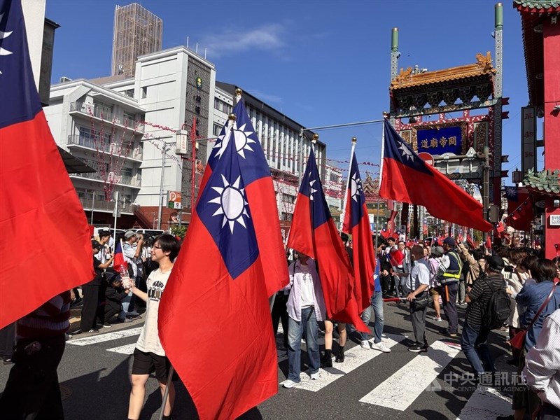 中華民国国旗を掲げ中華街を練り歩くパレードの参加者