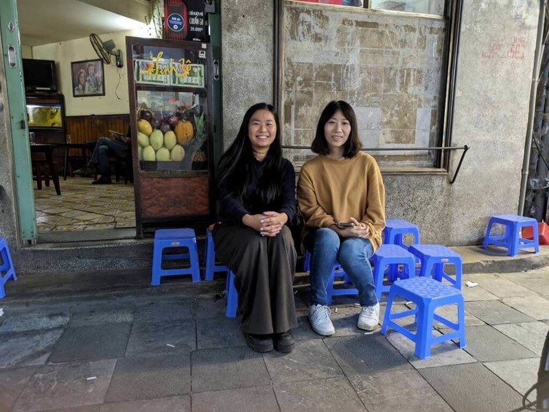 ハノイ市内の古い喫茶店の前で写真に写る張さん(左)と劉俐さん(右)=張さん提供