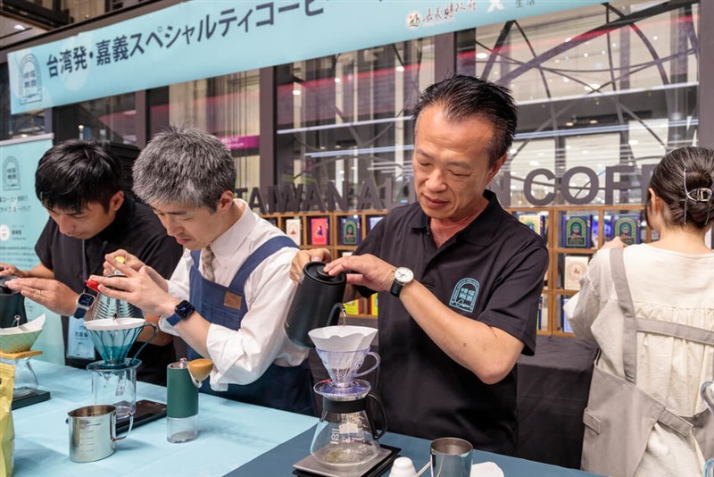 大阪市内の百貨店で県産コーヒーをPRし、ハンドドリップを披露する翁章梁嘉義県長（左3）＝同県政府提供