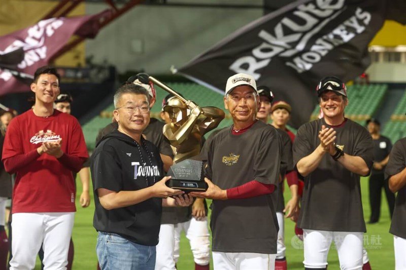 中華職業棒球大聯盟(台湾プロ野球リーグ、CPBL)の蔡其昌会長(手前左)から優勝トロフィーを受け取る楽天モンキーズの古久保健二監督=10月27日、台中市