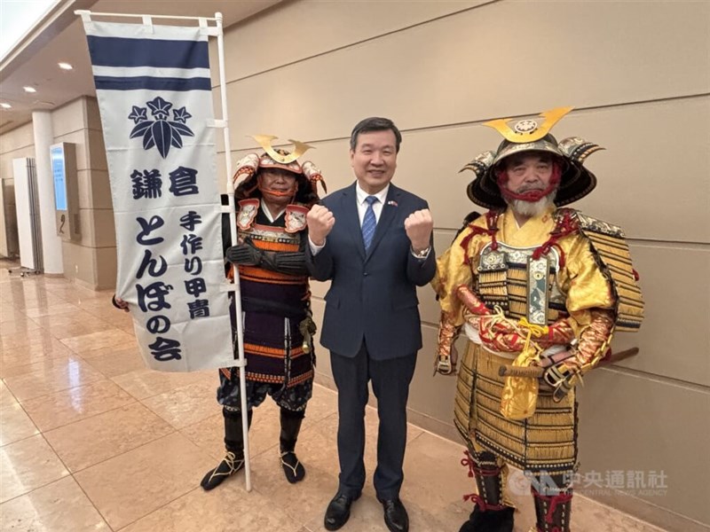 手作り甲冑（かっちゅう）隊のメンバーと写真に納まる李逸洋駐日代表（中央）＝11月4日、鎌倉市