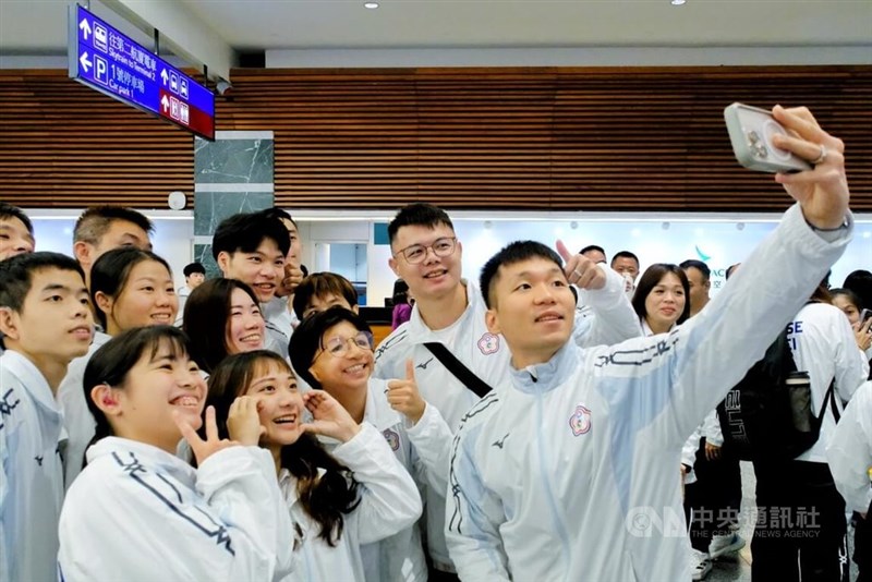 東京デフリンピックの台湾代表団の一部メンバーと自撮りする李洋運動部長（手前右）＝11月13日、桃園市