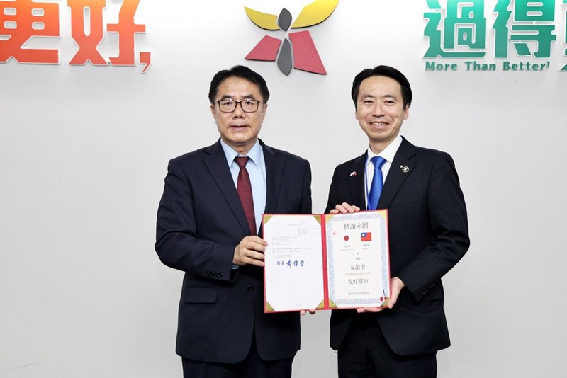 台南市の黄偉哲市長（左）から「山形路」の命名に関する公文書を受け取る山形市の佐藤孝弘市長＝11月12日、台南市（同市政府提供）