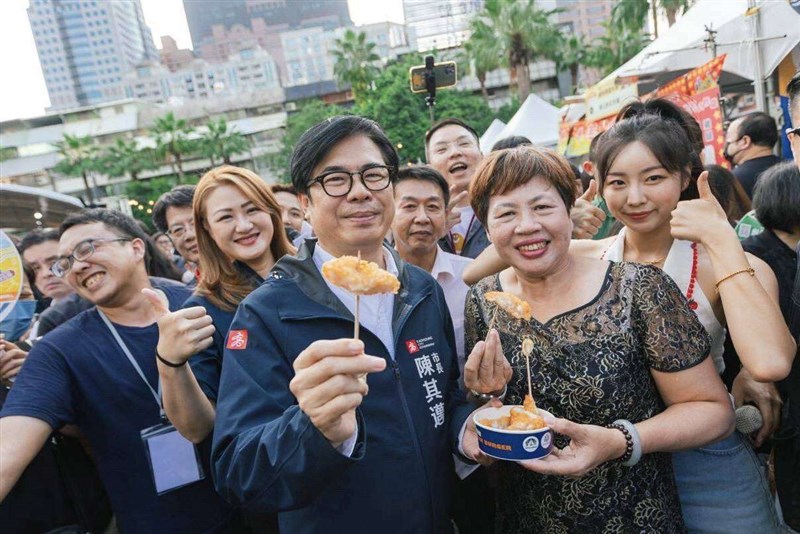 鹹酥鶏を楽しむ陳其邁(ちんきまい)高雄市長(中央)。(写真=高雄市政府観光局提供)