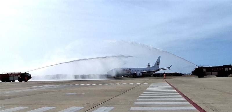 26日、マレーシアから澎湖に到着し、消防車によるウオーターアーチで歓迎を受けるチャーター便=澎湖空港提供