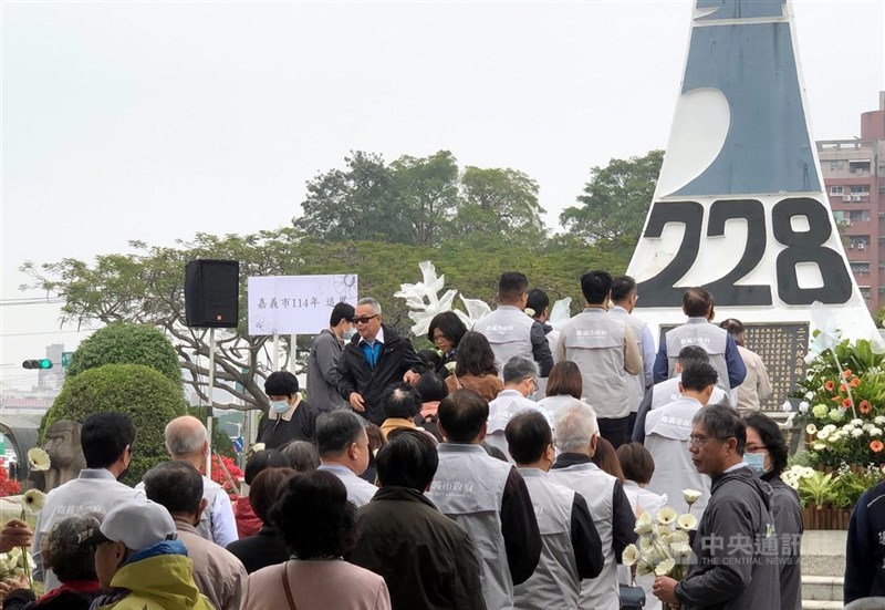 2月28日の平和記念日を前に、南部・嘉義市で2月26日、国民党政権が市民を弾圧した1947年の「2・28事件」を記念した追悼集会が行われた。犠牲者家族や参加者は列をなし、記念碑前に花を手向けた＝2025年2月26日、中央社記者黄国芳撮影