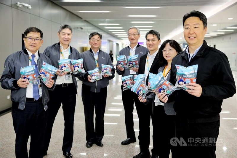 限定版のスナック菓子を旅行者に配る陳世凱交通部長(右端)ら=12月15日、桃園市