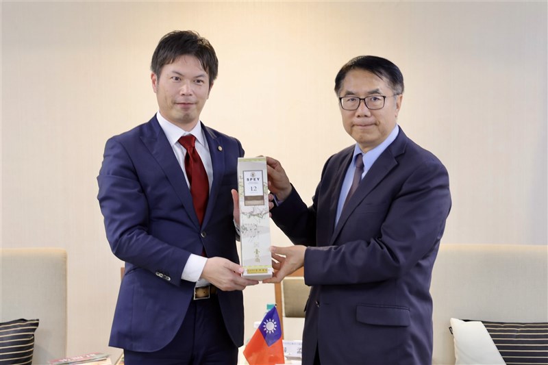 久保田正紀京都市議(左)に記念品のウイスキーを贈る黄偉哲台南市長=12月16日、台南市(同市政府提供)
