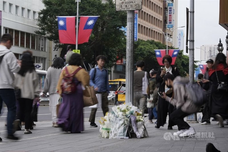 事件現場周辺に供えられた複数の花＝2025年12月20日、中央社記者徐肇昌撮影