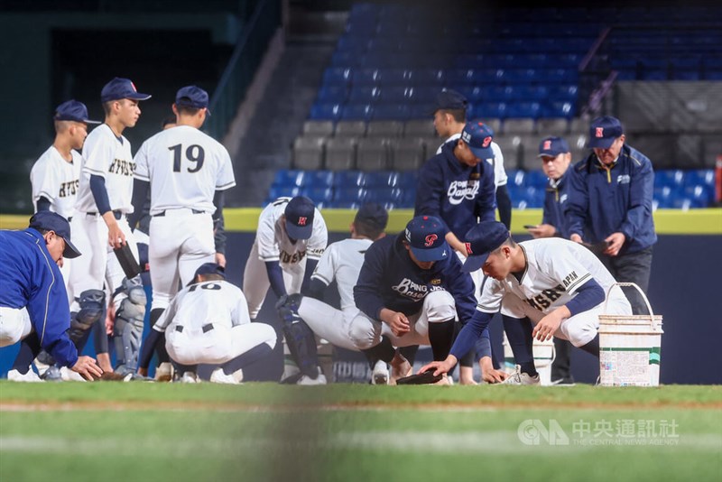 試合前、グラウンド整備を手伝う平鎮高、九州選抜の球児ら＝12月25日、新北市