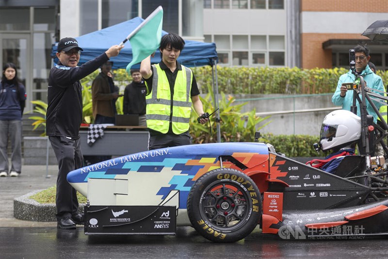 レース旗を振る台湾大学の陳文章学長=12月27日、台北市