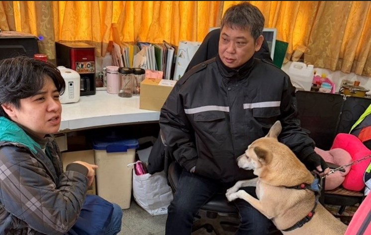 トレーナーの黄媛欣さん（左）のアドバイスを受ける警備員（右）＝新北市動物保護防疫処提供