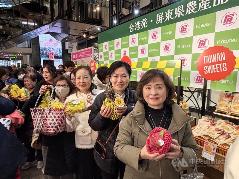 屏東県産の果物を手に笑顔を見せる日本の消費者＝3月12日、大阪市