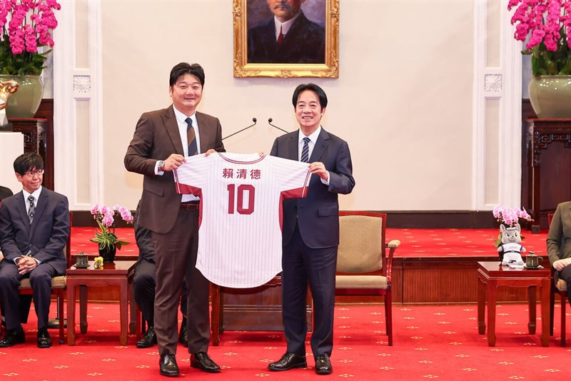 楽天モンキーズの曾豪駒監督（左）から特別仕様のユニホームを受け取る頼清徳総統＝3月26日、台北市（CPBL提供）