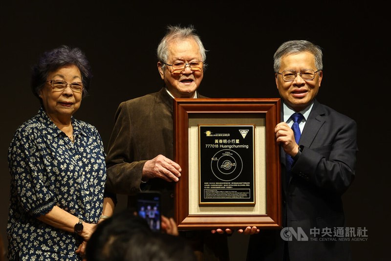 中央大学の蕭述三学長（右）から小惑星命名の記念額を受け取る作家の黄春明さん（中央）＝4月8日、台北市