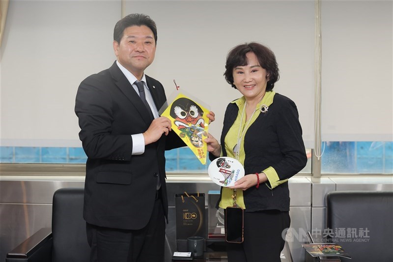 平戸市の伝統的な凧「鬼洋蝶」を中央社の胡婉玲社長（右）に手渡す松尾有嗣平戸市長（左）＝中央社本社で2026年4月27日、中央社記者翁睿坤撮影