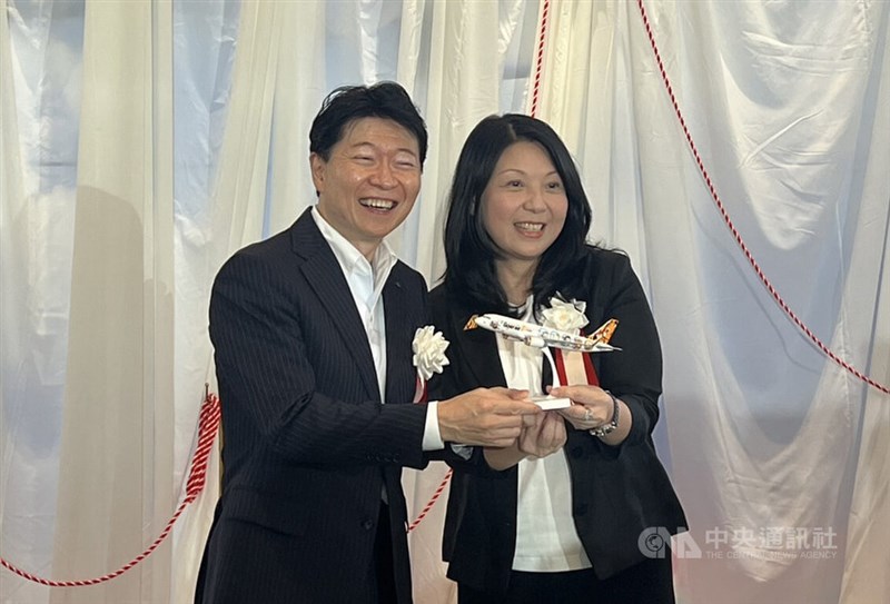 特別塗装機の模型を手に持つタイガーエア台湾の黄世恵会長（右）、伊原木隆太岡山県知事＝7月14日、岡山県