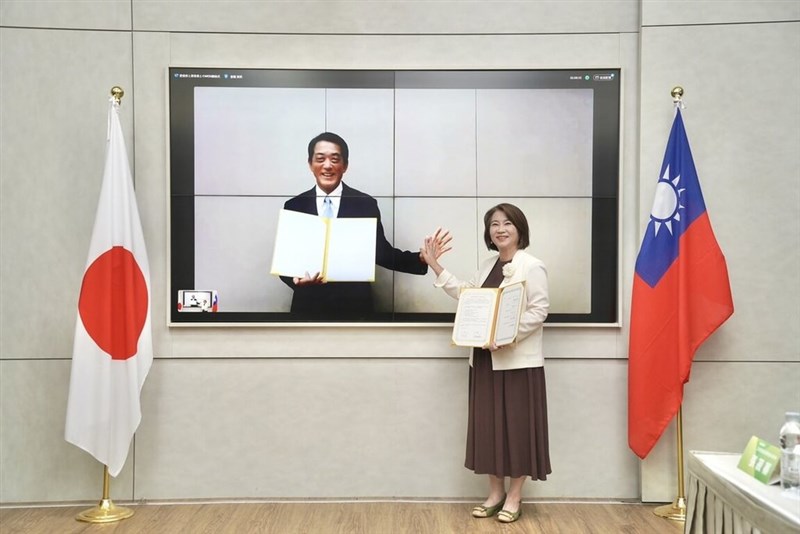 覚書締結式で「ハイタッチ」をする屏東県の周春米県長（右）と愛媛県の中村時広知事＝7月29日、屏東県（屏東県政府伝播・国際事務処提供）