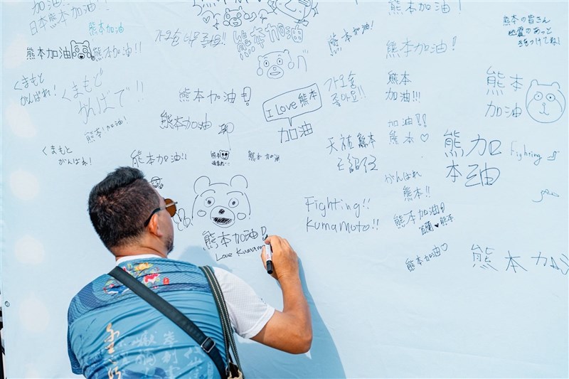 熊本県を励ますメッセージを応援ボードに書き込む男性＝高雄市政府提供