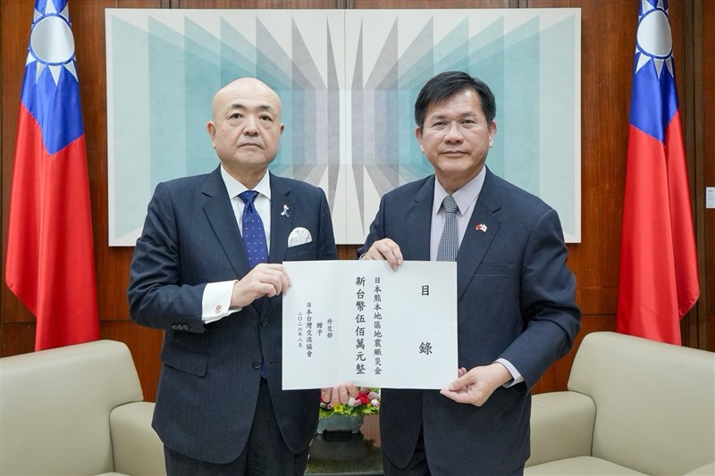 日本台湾交流協会台北事務所の片山和之代表（左）に義援金の目録を手渡す外交部の林佳竜部長＝8月6日、台北市（外交部提供）