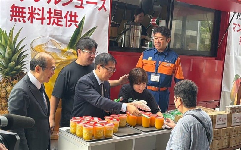 熊本地震を受け、宇城地域を訪れ、被災者にジュースを手渡して激励する黄偉哲・台南市長（右から3人目）＝台南市政府提供