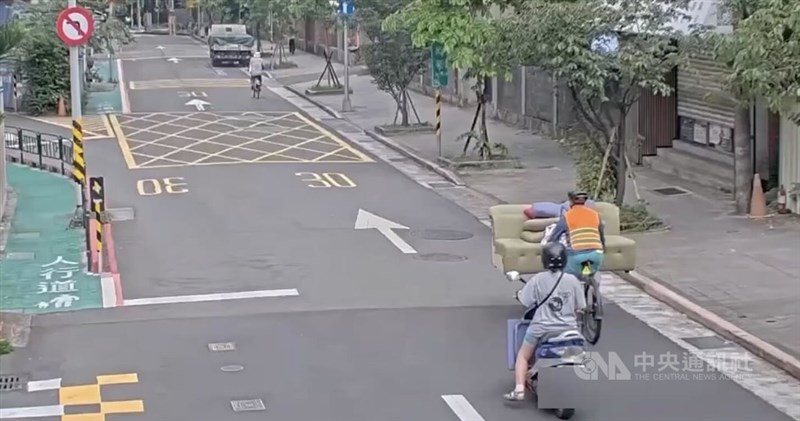自転車にソファを載せて運搬する男性（右）＝8月29日、台北市