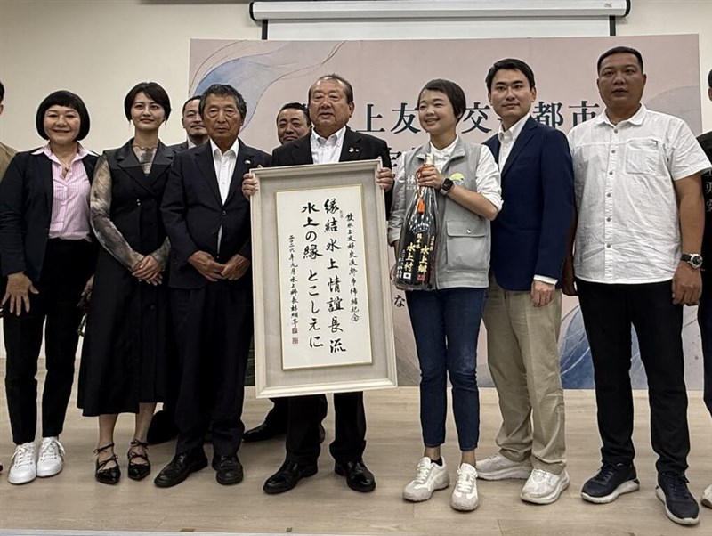 水上村の中嶽弘継村長（右から4人目）から焼酎を贈られた水上郷の林緗亭郷長（右から3人目）。右から2人目は陳冠廷立法委員＝9月17日、嘉義県水上郷（水上郷公所提供）