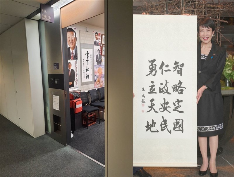 石破氏の事務所に掛けられている張さんの作品(左)、張さんの作品を手にする高市氏(右)=いずれも張さん提供