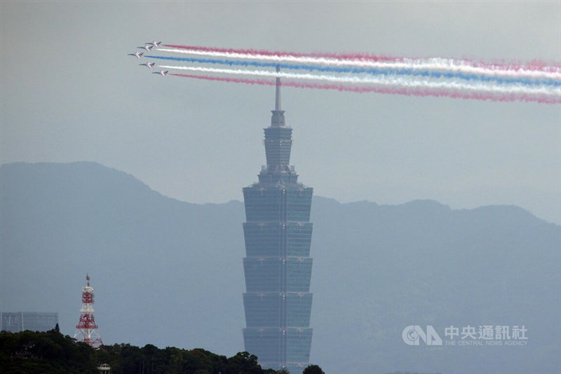 超高層ビル台北101を背に、赤、青、白のスモークを引いて台北市内を飛行するアクロバット飛行チーム「サンダータイガース」（雷虎小組）の高等練習機「勇鷹」＝2026年10月10日、中央社記者徐肇昌撮影