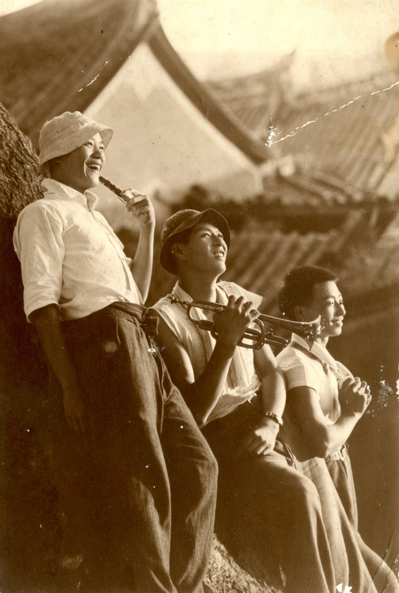 拿著樂器、戴著漁夫帽的年輕人,倚著250多年的老樟樹合影,真帥。(約1940年,吳金淼攝)