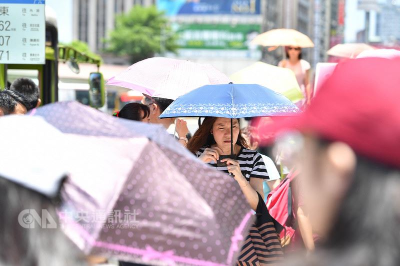 中央氣象局觀測,27日上午西半部高溫都超過33度,台北市氣溫飆到攝氏38.2度,是今年全台新高溫,氣象局提醒民眾外出注意防曬。圖為台北市街頭民眾撐傘遮陽。中央社記者王飛華攝 107年5月27日