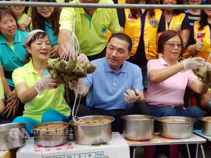 端午佳節將至,國民黨提名新北市長參選人侯友宜(前中)10日出席在蘆洲忠義廟前舉行的「萬粽飄香.關懷弱勢三蘆情」活動,與志工一起包愛心粽子助弱勢。中央社記者林長順攝 107年6月10日