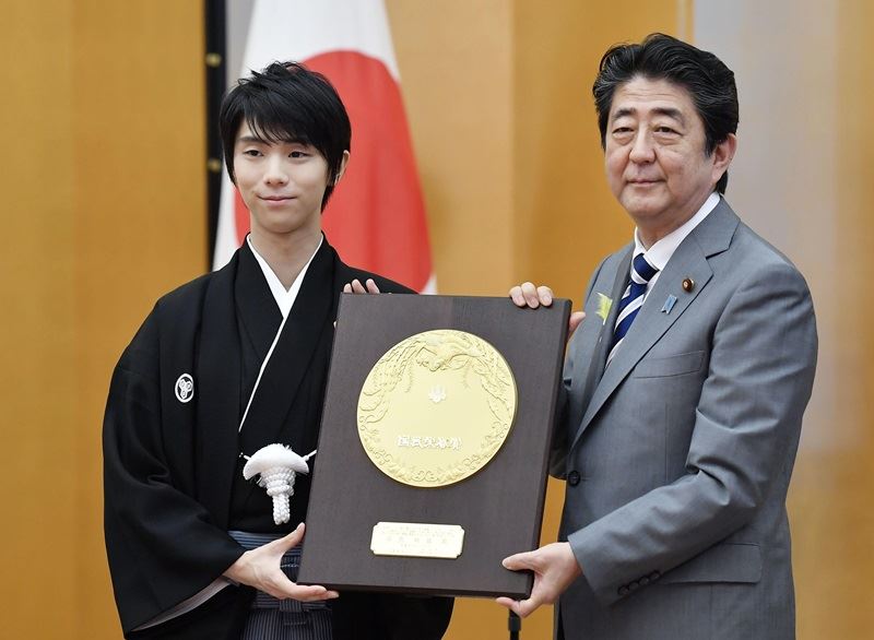 為日本奪下平昌冬季奧運男子花式滑冰金牌的滑冰王子羽生結弦,2日從日本首相安倍晉三手中接下國民榮譽獎殊榮,成為日本史上最年輕的獲獎人。(共同社提供)