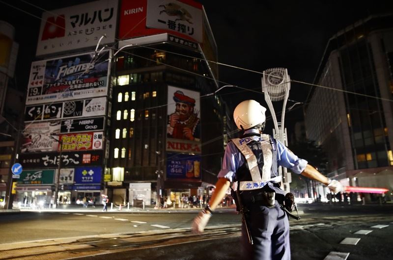 日本北海道發生規模6.7地震,境內有295萬戶停電,交警緊急指揮交通。(共同社提供)