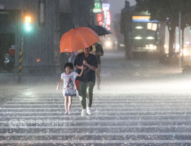 台北市區8日下午雲層密布,隨後伴著雷聲降下劇烈雨勢,整座城市灰濛一片,民眾緊牽著小朋友的手撐傘過馬路。中央社記者謝佳璋攝 107年9月8日