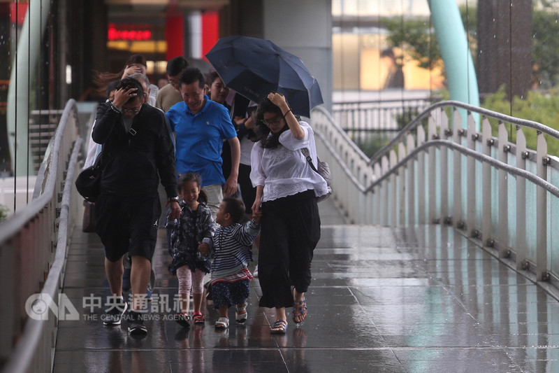 受鋒面和對流旺盛影響,中央氣象局9日對北北基發布超大豪雨特報,陽明山24小時累積雨量已經超過500毫米,預計10日雨勢才會趨緩。風雨大,在信義商圈天橋上行走的民眾都受到雨勢波及。中央社記者吳家昇攝 107年9月9日