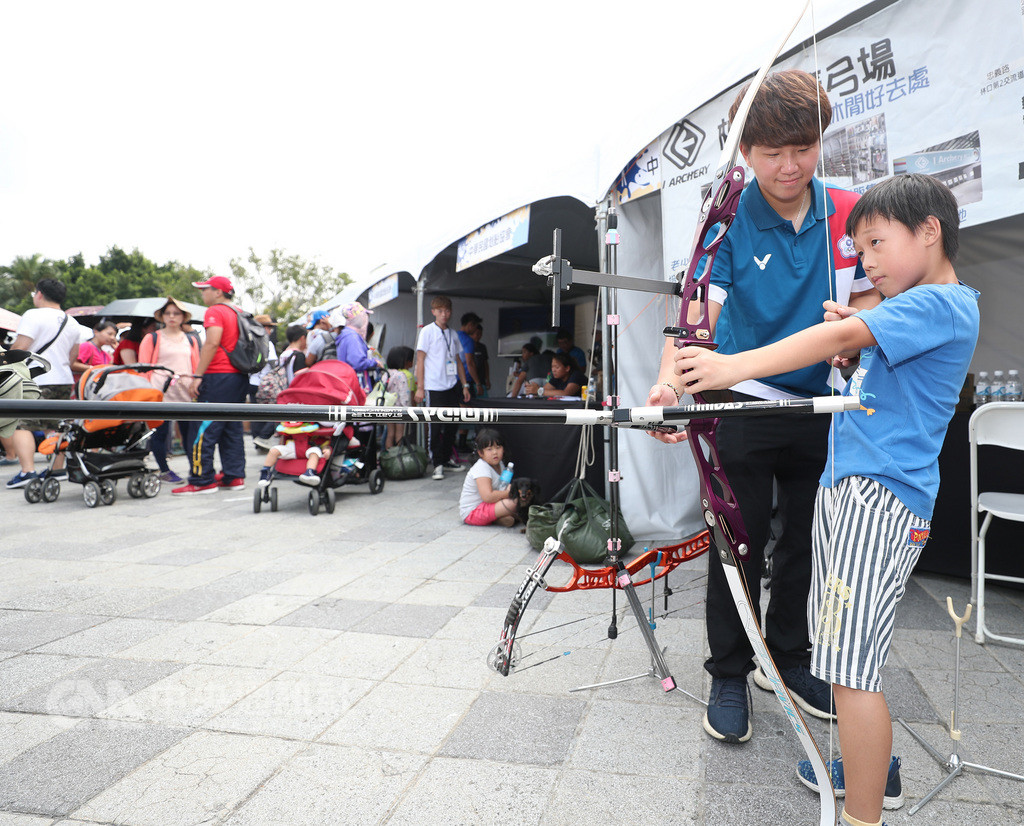 中華奧會22日在台北花博公園花海廣場舉辦首屆奧林匹克親子運動嘉年華,亞運複合弓混雙賽金牌選手陳怡瑄(右2)陪小朋友體驗射箭。中央社記者張新偉攝 107年9月22日