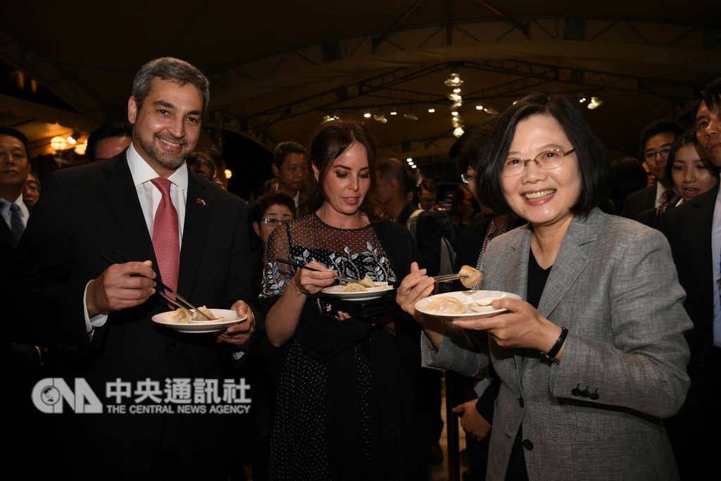 總統蔡英文(前右)10日晚間在台北賓館出席中華民國107年國慶酒會,向友邦巴拉圭總統阿布鐸(前左)推介台灣美食小籠包。中央社記者施宗暉攝 107年10月10日